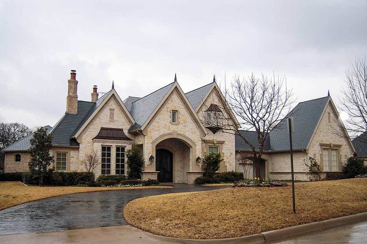 a large house that is in the middle of some grass and trees with water coming out of it