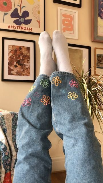 the legs and ankles of a person wearing blue jeans with flowers on them are shown