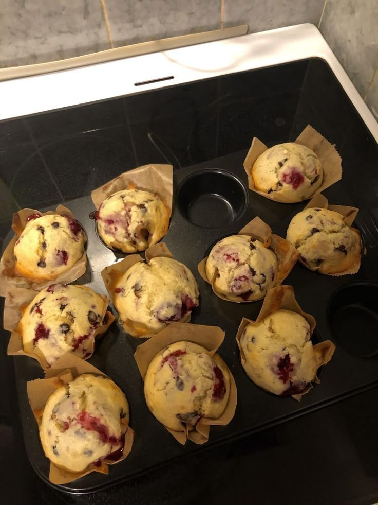 several muffins sitting on top of a black tray next to a cupcake tin