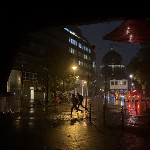 two people running in the rain at night