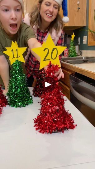 two children are making christmas trees out of tinsels and paper stars with numbers on them