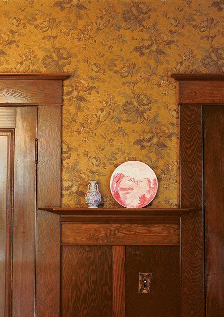 a wooden shelf with a vase on top of it in front of a wall paper