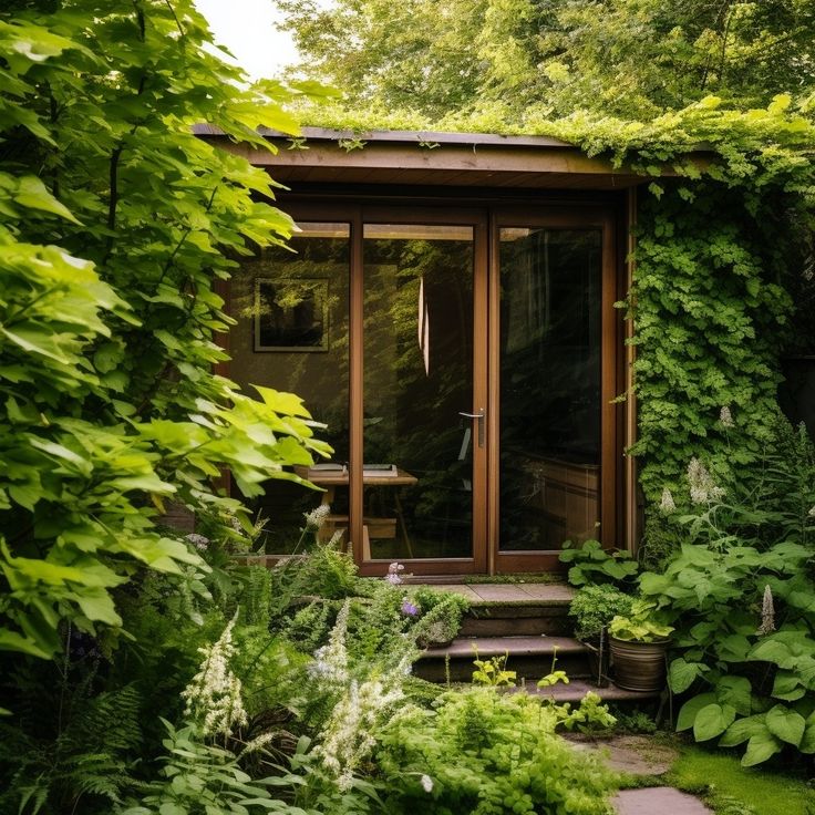 a small house surrounded by greenery in the middle of a garden with steps leading up to it