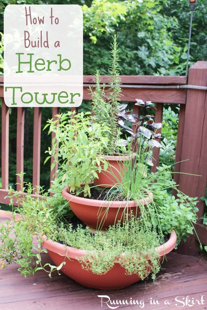 three clay pots filled with herbs sitting on a deck next to a sign that says how to build a herb tower