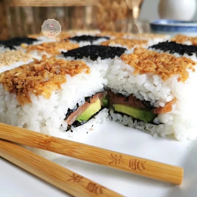 a plate with some sushi and chopsticks on it