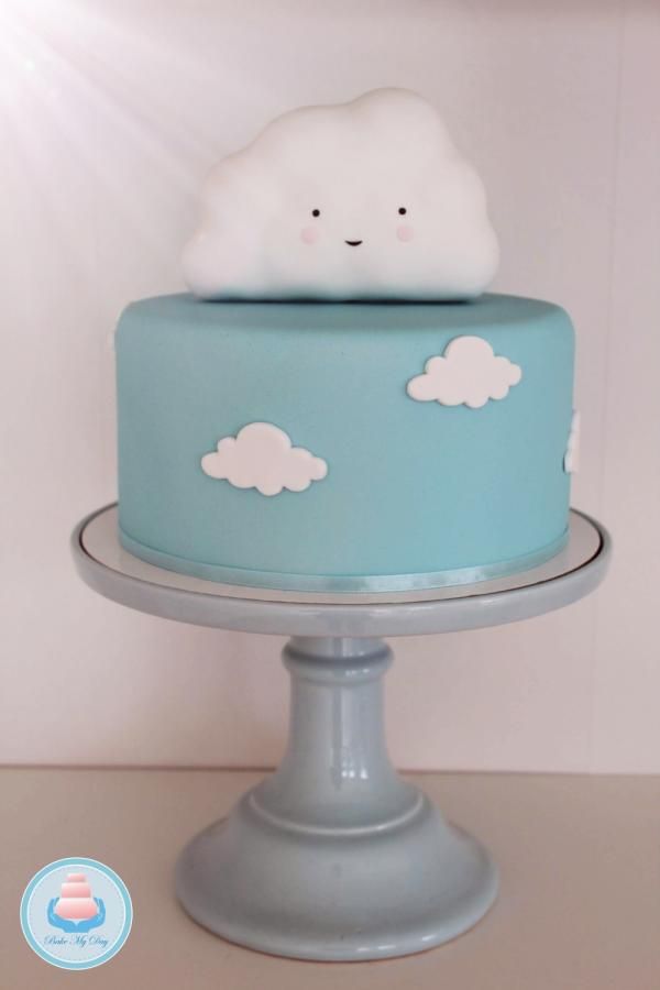 there is a blue cake with white clouds on it