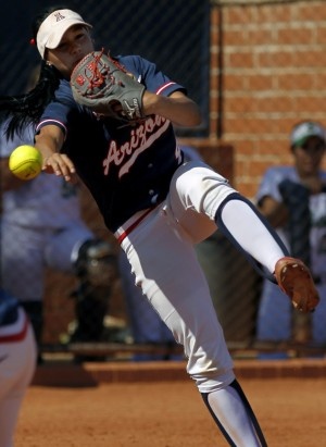 a baseball player pitching a ball on top of a field with other players in the background