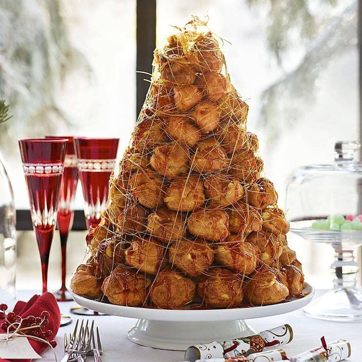 a christmas tree made out of croissants on a white platter with silverware