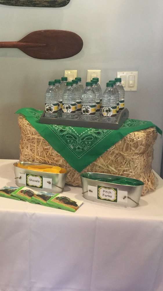 a table topped with lots of bottles of water on top of a white table cloth