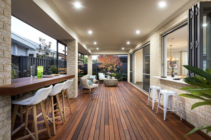 an outdoor living area with wood flooring and bar stools