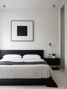 a bedroom with white walls and black furniture