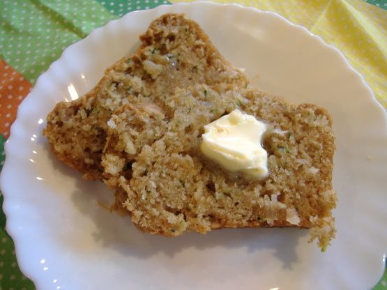 two pieces of cake on a white plate with butter and green polka dot tablecloth