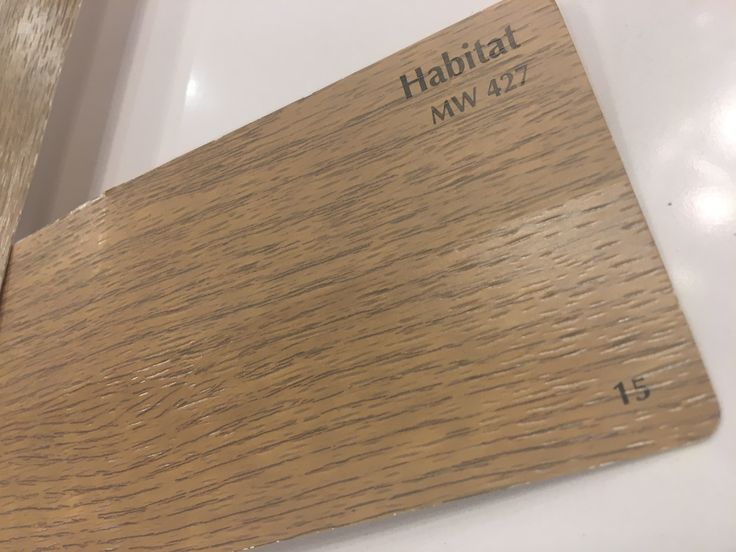 a close up of a wooden floor with the name habitat on it's side