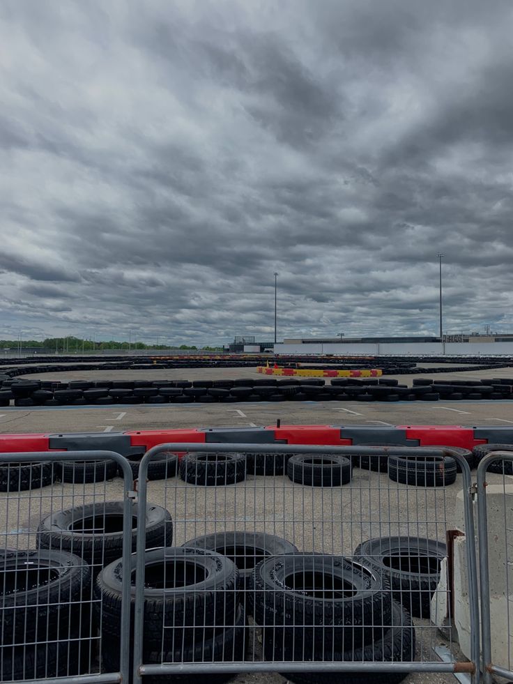 several tires are lined up in front of a fence on the tarmac at an airport