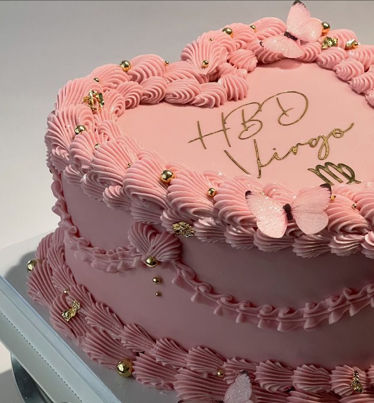 a pink heart shaped cake with gold decorations