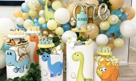 a birthday party with balloons, cake and decorations in the shape of animals on cylinders