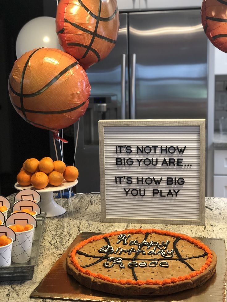 a basketball themed birthday cake with balloons and decorations in the background, it's not how big you are