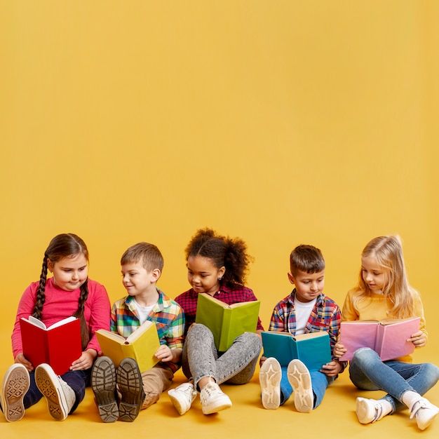 five children sitting on the floor reading books