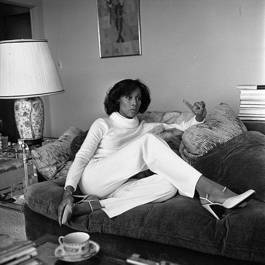 a black and white photo of a woman sitting on a couch