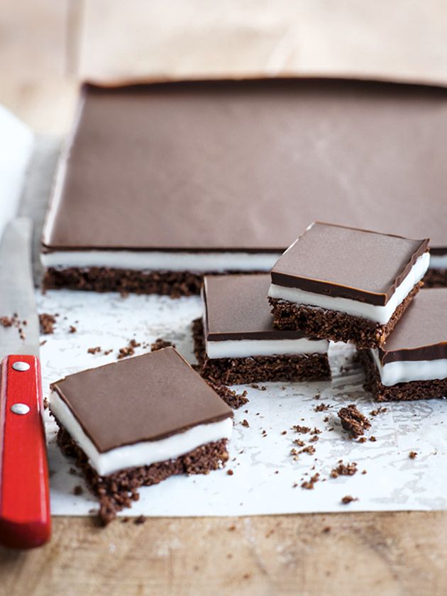 several pieces of cake sitting on top of a white counter next to a red knife