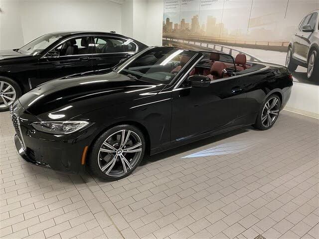 two black cars are parked in a showroom