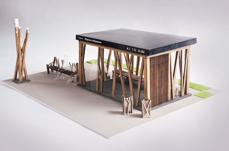 a model of a small wooden structure with benches and trees around it on a white background