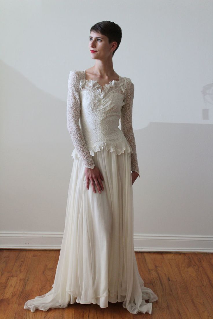 a woman in a white dress standing on a hard wood floor with her hands on her hips