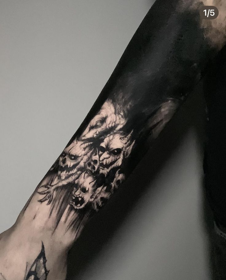 a man's arm with a black and white tattoo design on the left forearm