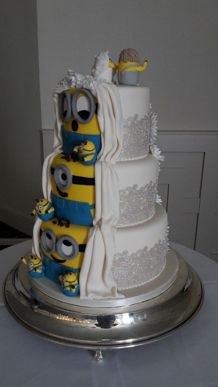 a three tiered wedding cake with minion decorations