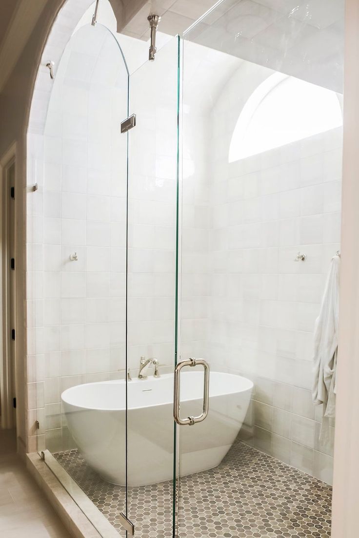 a white bath tub sitting next to a walk in shower