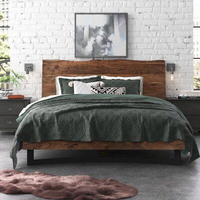 a bedroom with white brick walls and green bedding, along with an animal rug