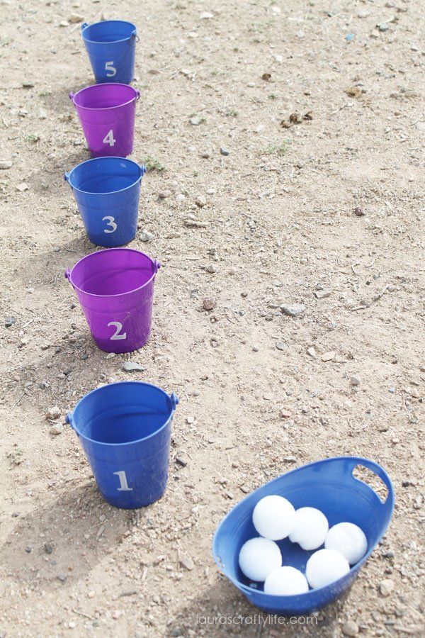 several buckets with balls in them sitting on the ground next to numbers and numbers