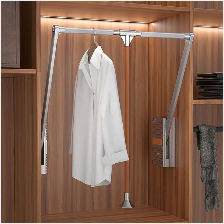 an open wooden closet with clothes hanging on hooks and towel racks in front of it