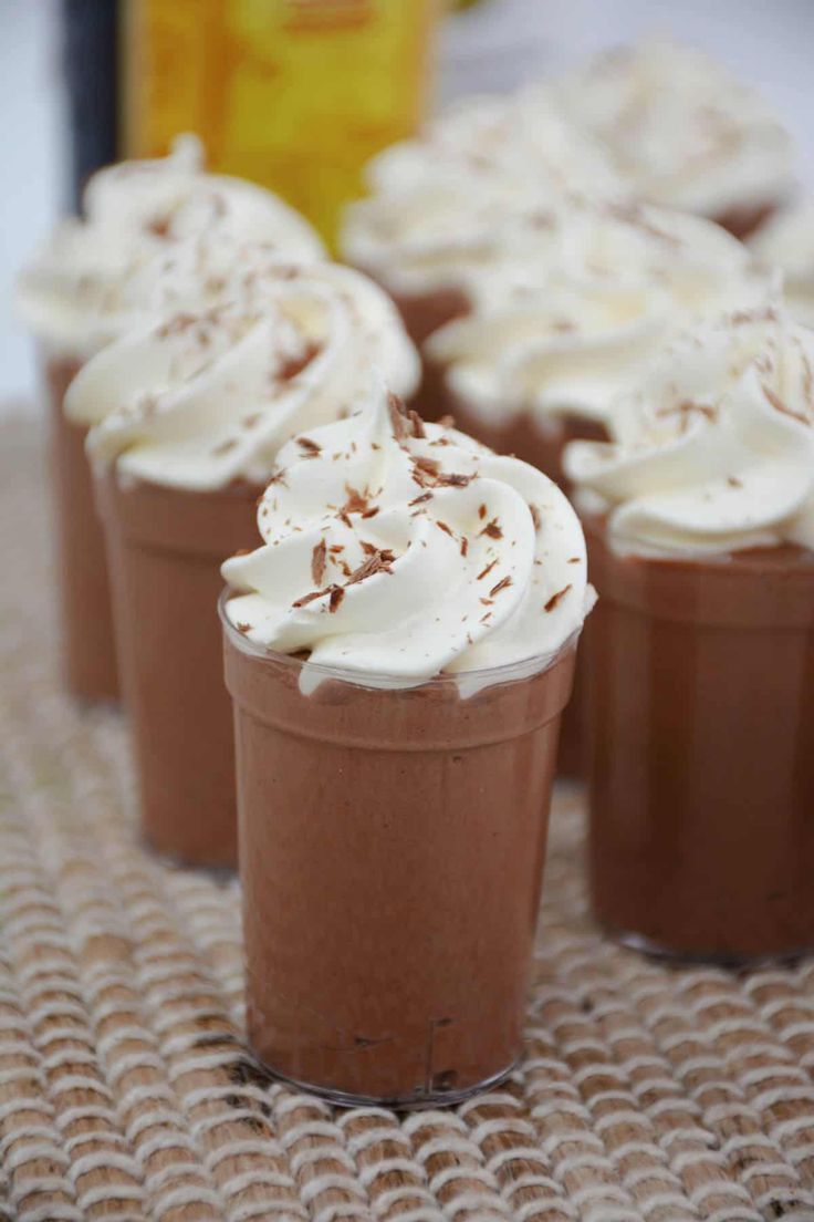 chocolate cups with whipped cream in them on a table