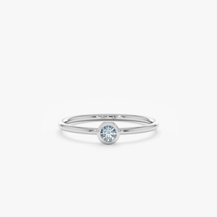 a white gold ring with a light blue diamond