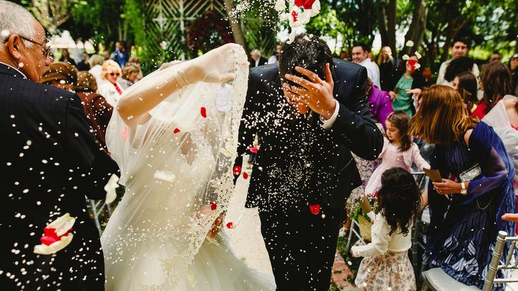 the bride and groom are showered with confetti