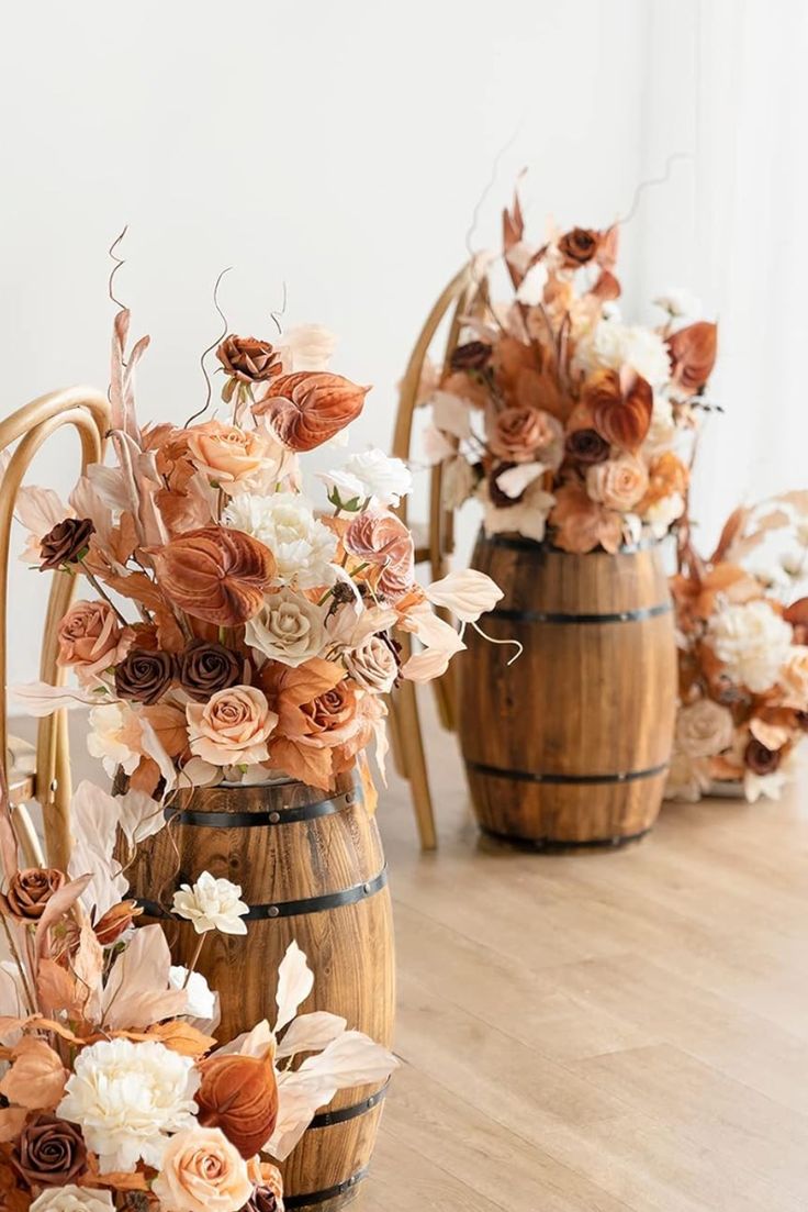 three wooden vases filled with flowers sitting on top of a table next to each other