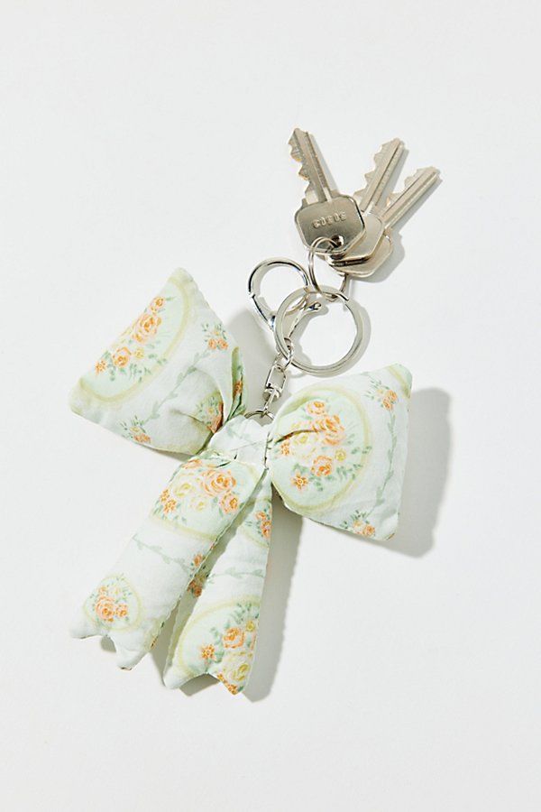 a keychain with a bow on it and two keys hanging from the back