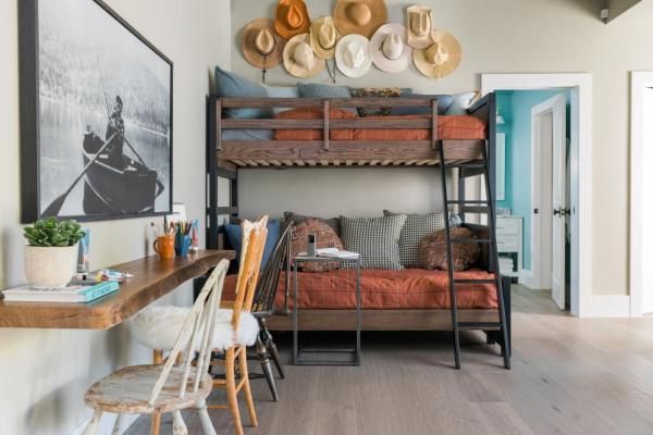 a bunk bed sitting in the middle of a living room next to a wooden table