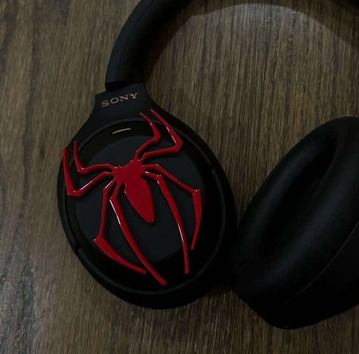 a pair of headphones with a red spider logo on it