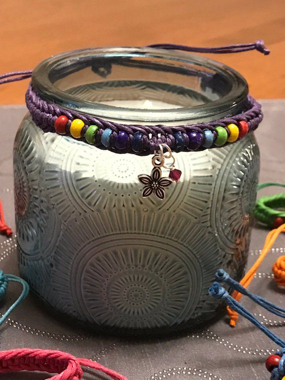 a glass jar sitting on top of a table covered in bracelets