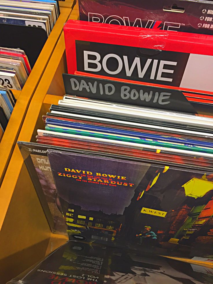 various records are stacked on top of each other in a store display case for sale