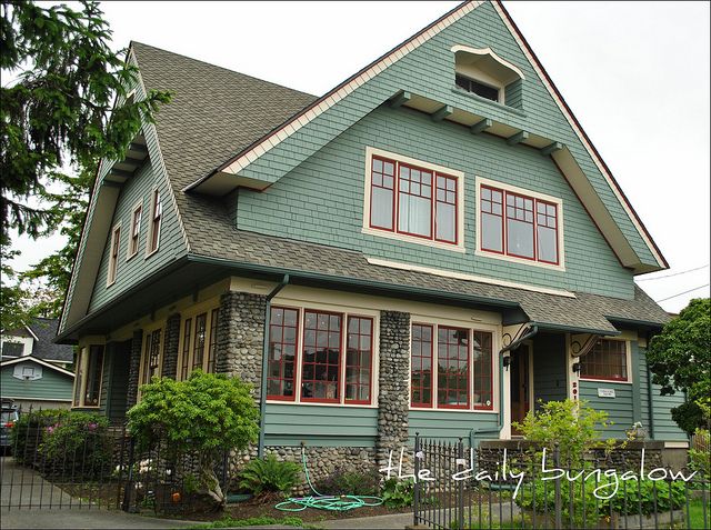 a green house with red trim and windows