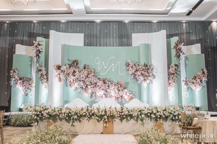 the wedding stage is decorated with flowers and greenery