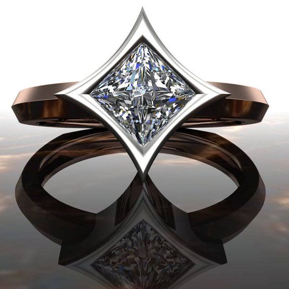 a diamond ring sitting on top of a reflective surface