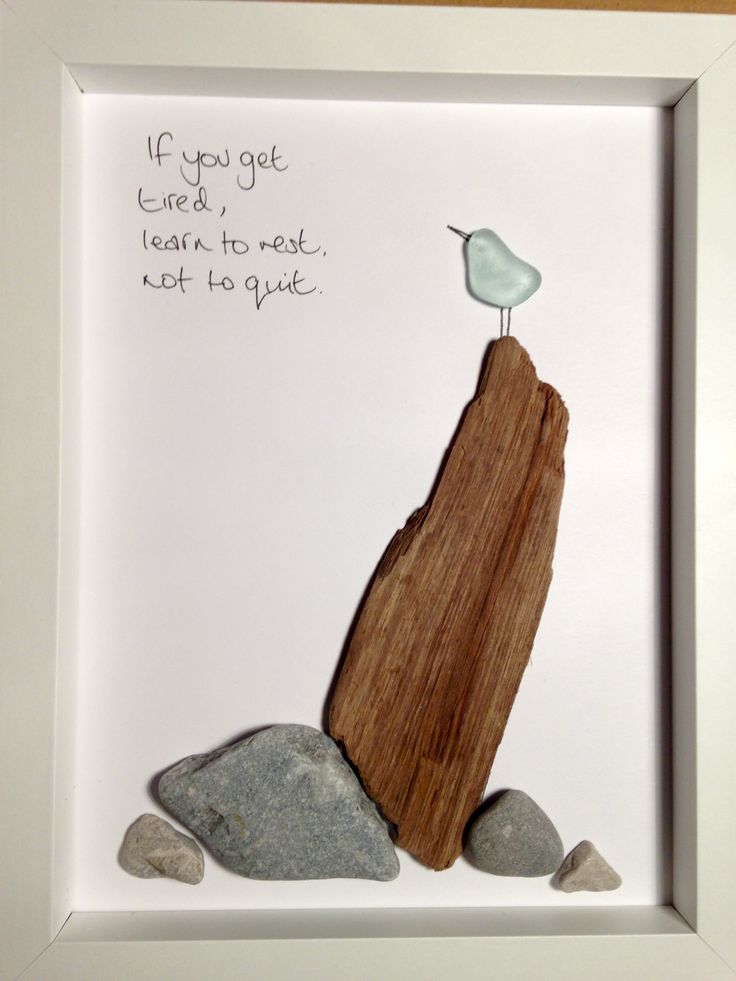 a wooden piece with a bird sitting on top of it next to rocks and a poem