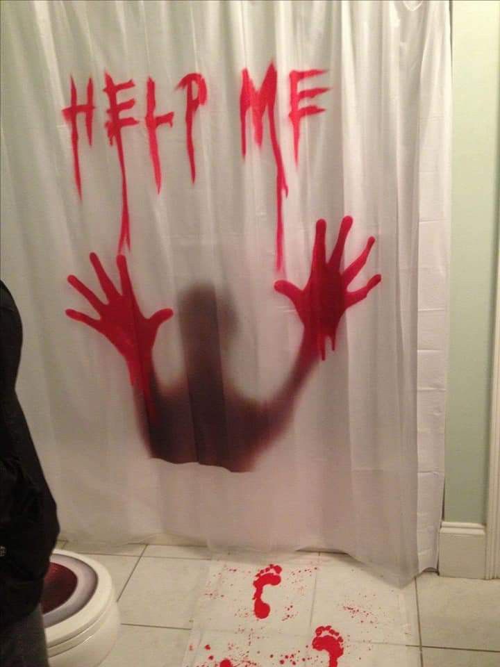 a shower curtain with red paint on it that says help me