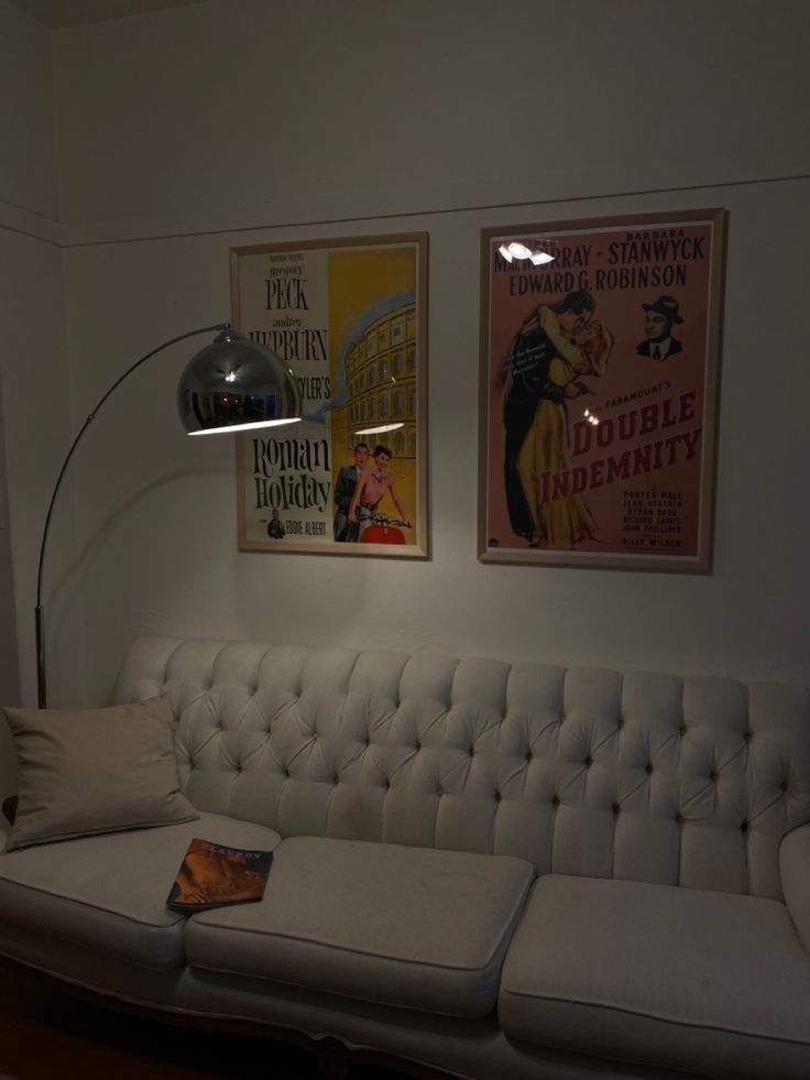 a living room with a couch, lamp and pictures on the wall