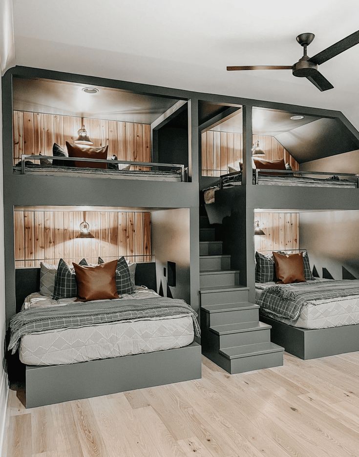 a bedroom with bunk beds and stairs leading to the upper floor, while another bed is in the middle of the room