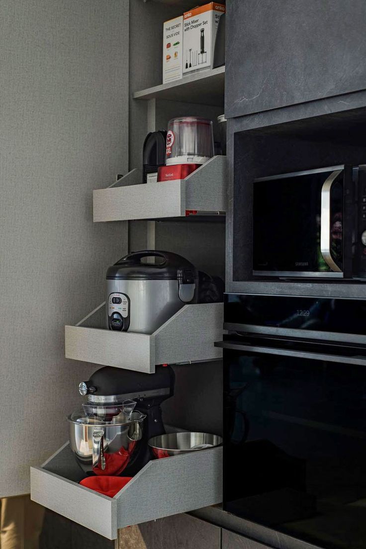 an oven and microwave in a kitchen with shelves on the wall next to each other